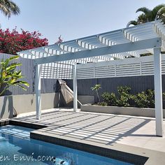 a swimming pool with a white pergolated cover over it