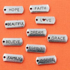 six metal tags with words that say faith, love, and family on them against an orange background