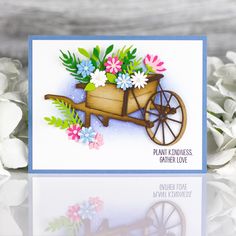 a card with flowers in a wheelbarrow