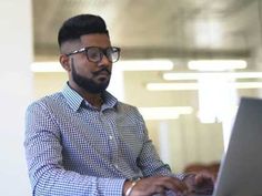 a man sitting at a table using a laptop computer