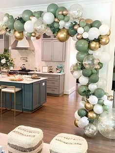 a kitchen filled with lots of white and green balloons