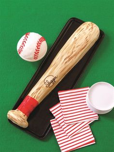 a baseball bat, ball and napkins on a tray