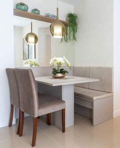 a dining room table with two chairs and a bench in front of the mirror on the wall