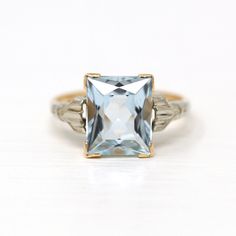 Gorgeous vintage circa 1940s retro era 14k yellow & white gold genuine aquamarine ring! This lovely ring features a rectangular faceted 3.44 carat genuine aquamarine gemstone, that is set in V prongs. There are pretty milgrain details on both shoulders. A stunning piece of fine 1940s era jewelry, featuring March's birthstone!  ERA - Circa 1940s / Retro   METAL / MATERIAL - 14k yellow & white gold, genuine aquamarine (approx. 3.44 CT)  MARKINGS / HISTORY - Inside of band is marked 14k CONDITION - Good vintage condition. Yellow gold metal has been professionally polished & cleaned. Genuine aquamarine is secure. Amazing vintage aqua ring!   SIZE / MEASUREMENTS - Size: 5.5, Ring Head Height: 10.6 mm, Rise Of Ring Off Finger: 6.1 mm, Back of Shank: 1.3 mm, Genuine Aquamarine: 10 x 8 mm, Weight: Vintage Aquamarine Rings For Formal Occasions, Vintage Aquamarine Gemstone Rings, Classic Light Blue Emerald Cut Jewelry, Classic Light Blue Rings For Anniversary, Classic Light Blue Topaz Ring For Formal Occasions, Classic Aquamarine Rectangular Ring, Classic Rectangular White Gold Topaz Ring, Classic Light Blue Topaz Ring For Anniversary, Vintage Solitaire Topaz Ring