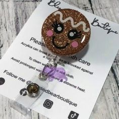 a badge holder with a brown glittered face on it's side and a name tag attached to it