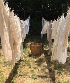 some clothes hanging out to dry on a line in the grass next to a basket