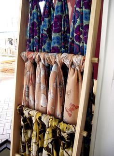 the tie rack is filled with many different types of scarves hanging on it's sides