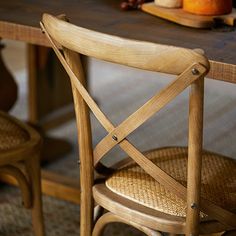 two wooden chairs sitting next to each other at a table