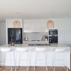 a kitchen with white counter tops and bar stools