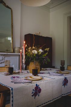 a dining room table with flowers and candles on it