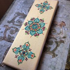 an embroidered piece of cloth sitting on top of a wooden table