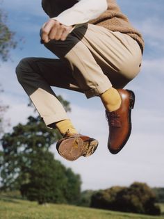 a person jumping in the air with their shoes on and one foot up above his head