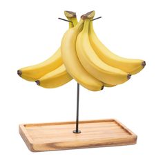 a bunch of bananas sitting on top of a wooden tray next to a banana holder