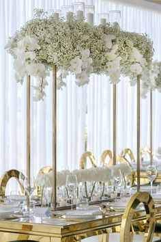 the tables are set with white flowers and crystal vases for centerpieces on each table