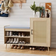 a wooden cabinet with shoes and hats on it next to a wall mounted coat rack