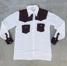 *CALI BIN Vintage Colorblock Button Up Shirt Brown and white  Circa 60s/70s. LABEL: Unbranded SIZE: Small /Medium Pit to pit-19”, length-27”, shoulder-17”, sleeve-25”, Length-29" COLOR: White MATERIAL: 100% Pure Cotton. CONDITION: Deadstock never been washed or worn. Stain on the collar. See last pic Care: Hand wash cold, hang to dry or dry flat. Press as needed with a warm iron. Please remember that all vintage items are at least 20 years old. Usually, they have been worn, used, and loved. We t Retro White Tops With Buttons, Retro White Buttoned Tops, Retro White Shirt With Buttons, White Retro Shirt With Buttons, Retro White Button-up Shirt, White Retro Button-up Shirt, Retro Brown Shirt With Button Closure, Vintage Beige Shirt With Button Closure, Vintage Brown Shirt With Button Closure