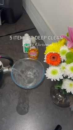 a vase filled with flowers sitting on top of a counter next to a pot and saucer