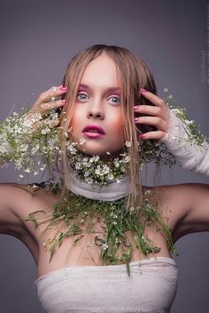 a woman with flowers on her neck and hands behind her head