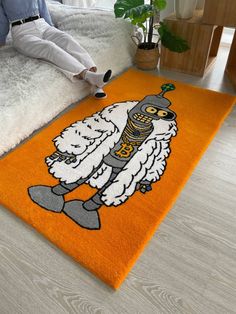 a man sitting on the floor with an orange rug in front of him that has a cartoon character drawn on it