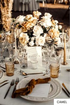 the table is set with silverware and white flowers