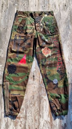 If you love the military style, our military cargo pants will be irresistible to you. Made with high-quality materials and embellished with manual workmanship, these pants are unique and original. Each piece is created with attention to detail, with practical pockets and handcrafted decorations that give a distinctive character. The production is not in series: each piece is handmade in Italy, thus guaranteeing an exclusive and tailor-made product for those looking for something special. The photos shown are indicative of the general style, but each pair of pants features similar but unique decorations, making each piece a work of art in itself. Thanks to the limited edition and craftsmanship, you will have a product that not only completes your outfit with a military touch, but that stand Upcycle Pants, Cargo Camo Pants, Army Cargo Pants, Army Clothes, Military Cargo Pants, Army Style, Style Trousers, Handcrafted Decor, Army Fashion