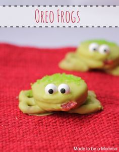 some cookies with googly eyes and green frosting are on a red towel that says oreo frogs made to be a momma