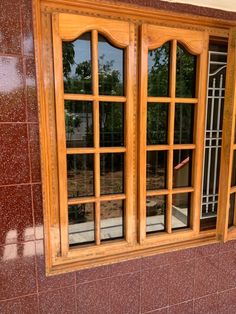 an open window on the side of a building with red tiles and wood trimmings