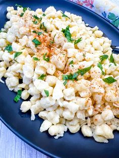 a blue plate topped with macaroni salad and garnished with parsley