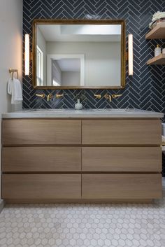 a bathroom vanity with a large mirror above it