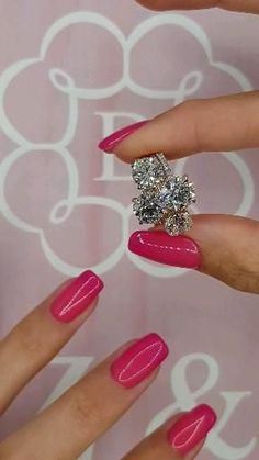 a woman's hand with pink manies and a diamond ring on her finger