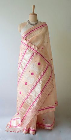 Handloom Organza Silk Sari from our looms in Assam.  Lightweight , breezy and comfortable to carry , these kind of silk is locally known as 'Kesa Pat ' .The sari is sheer with a crisp hand ( organza ) and very light.  The body has raw mulberry silk in the warp and weft and the extra weft motifs in tested silver zari and cotton. The design motifs are typical of the region and are used in a more contemporary design in this sari .  The Sari comes with blouse piece that has a plain body and borders. Traditional Beige Dupatta For Summer, Traditional Cream Dupatta For Summer, Traditional Cotton Silk Saree For Summer, Bohemian Pink Saree For Summer, Pink Bohemian Saree For Summer, Pink Art Silk Saree, Traditional Pink Summer Saree, Festival Pink Organza Saree, Pink Semi-stitched Raw Silk Saree