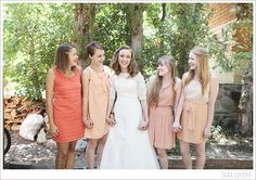 a group of women standing next to each other in front of a tree filled park