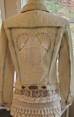 the back of a woman's jean jacket with crochet