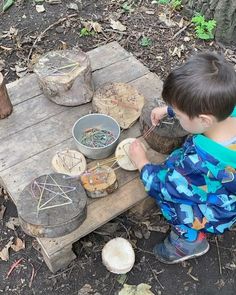 a young boy sitting on a wooden bench making something