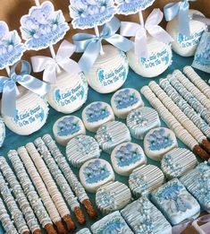 a table topped with lots of cookies covered in frosting and blue decorations on top of it