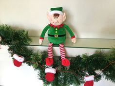 an elf doll hanging from a christmas garland