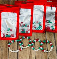 three bags filled with beads sitting on top of a wooden floor next to each other