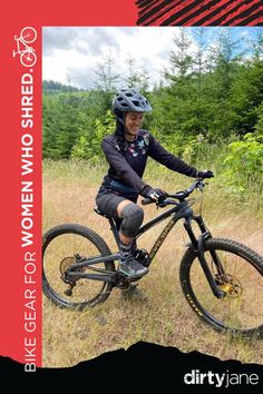 a woman is riding her mountain bike in the grass