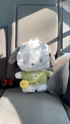 a stuffed animal wearing goggles in the back seat of a car