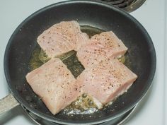 four pieces of fish are cooking in a skillet on the stove top, ready to be cooked