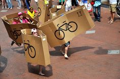 some people are carrying cardboard boxes with bikes on them