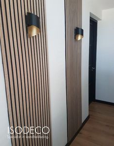 two black and white striped wall lights next to each other in a room with wood flooring