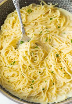 a bowl filled with pasta and topped with parsley