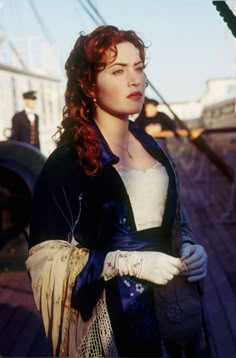 a woman with red hair is standing on the dock and looking off into the distance