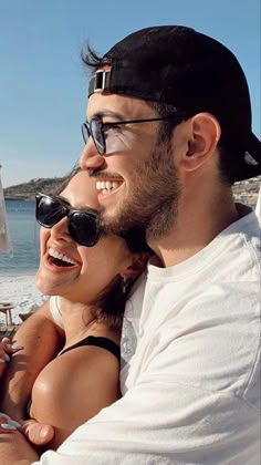 a man and woman taking a selfie on the beach