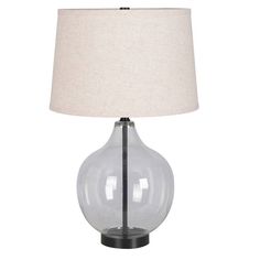 a clear glass table lamp with a beige linen shade on the bottom and black base