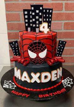 a spiderman birthday cake with the number four on it's top and decorations