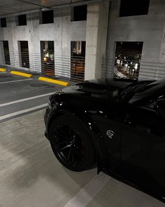 a black sports car parked in a parking garage