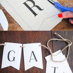 someone is cutting out letters with scissors to make them look like they are hanging on the wall