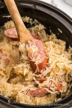 a slow cooker filled with rice and sausage